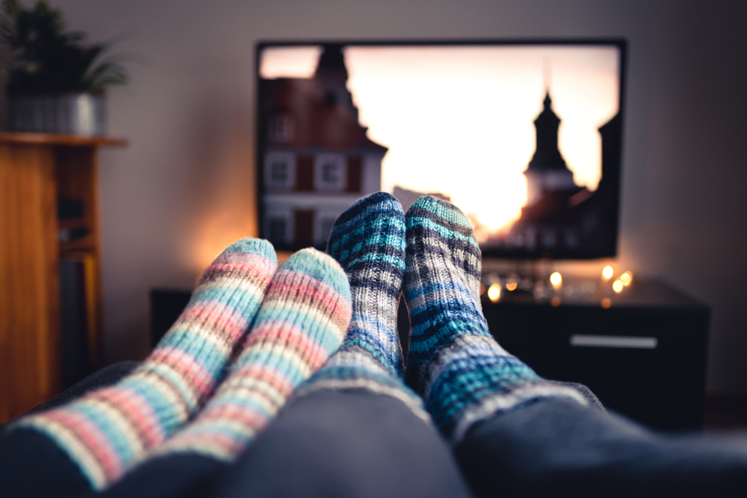A couple watching TV with their feet up.