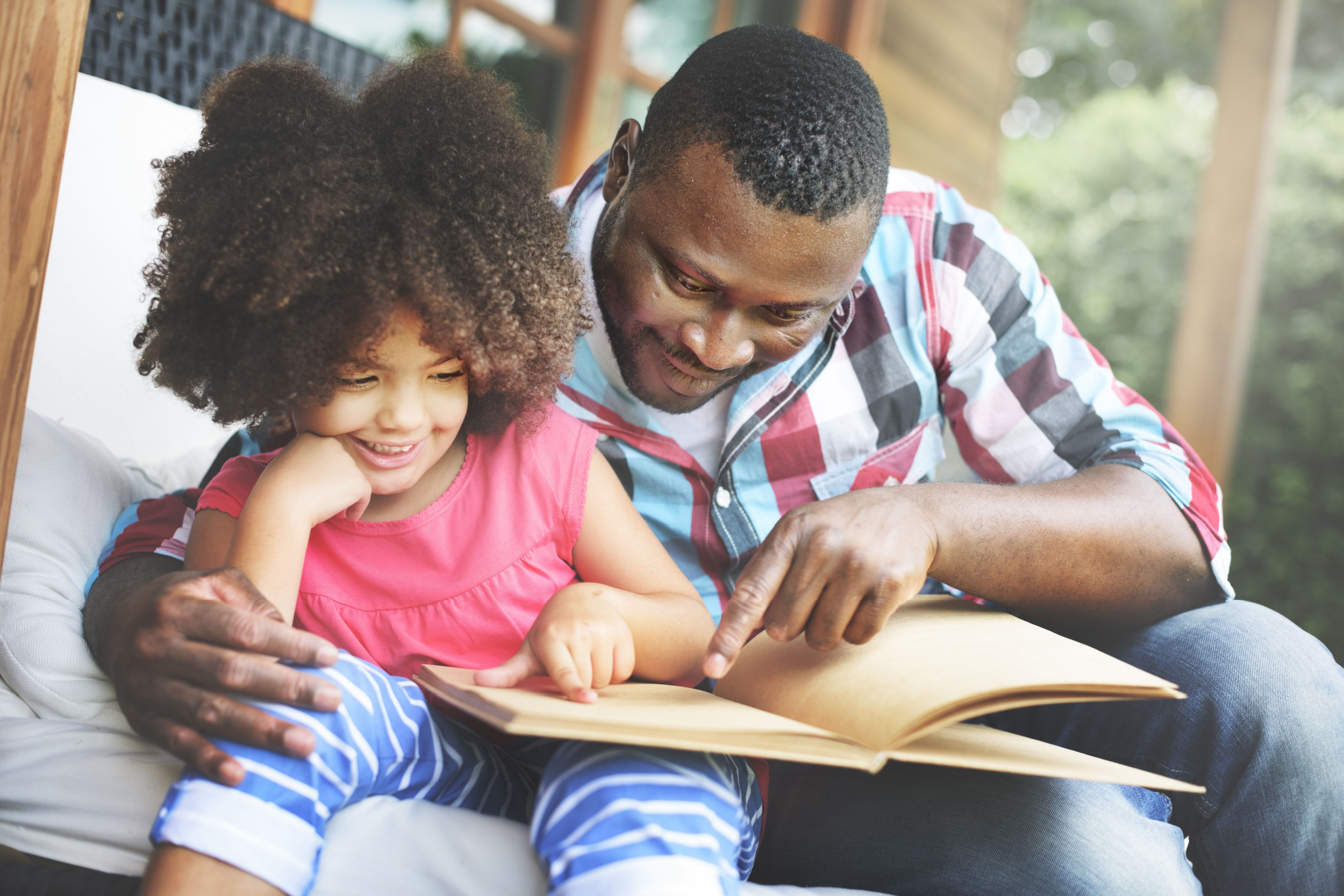A father and his daughter reading together.