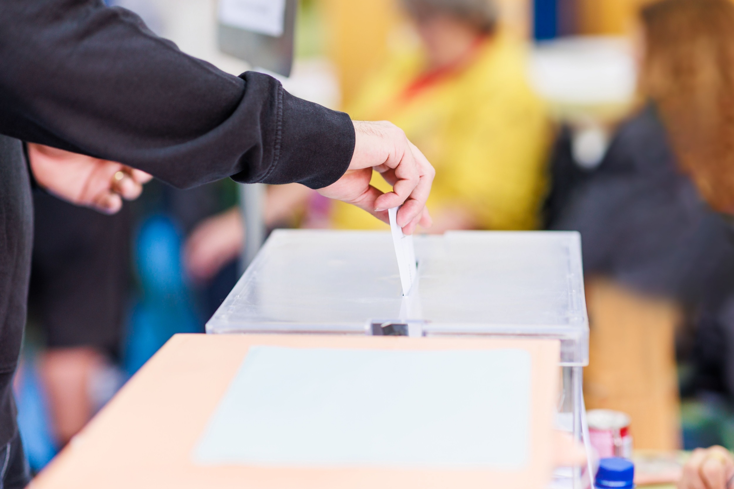 A man voting using a ballot box.