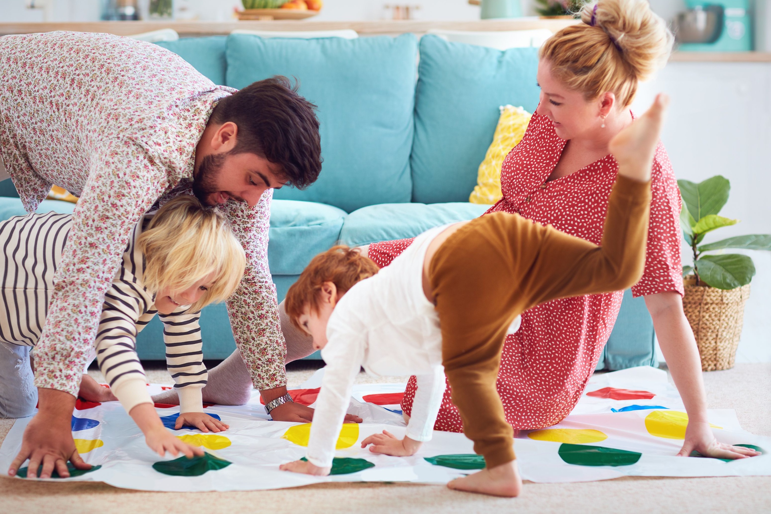 A family with young children playing Twister