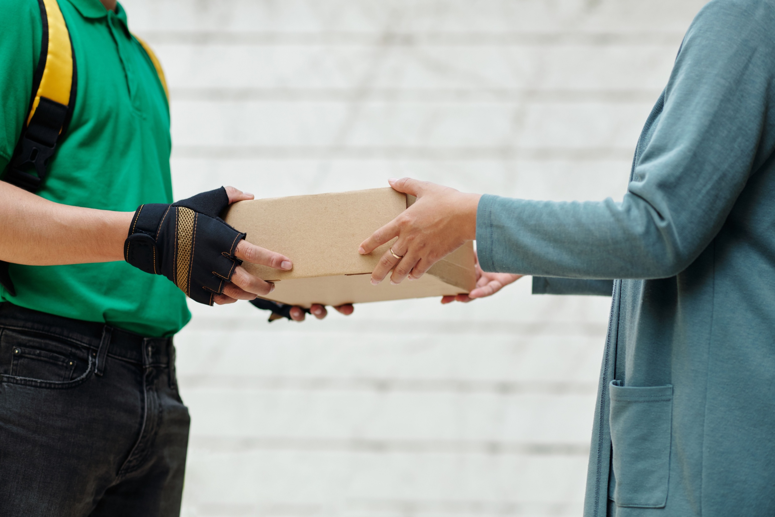 A delivery man handing a customer a parcel.