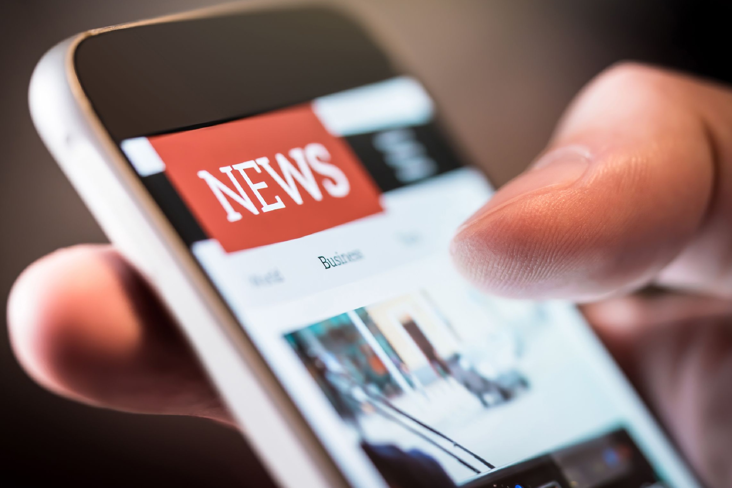 A person using a smartphone to read the news.