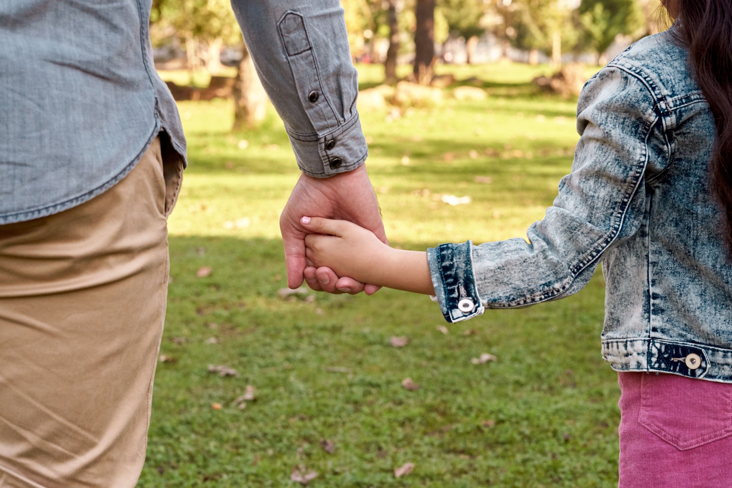 Parent and child holding hands.