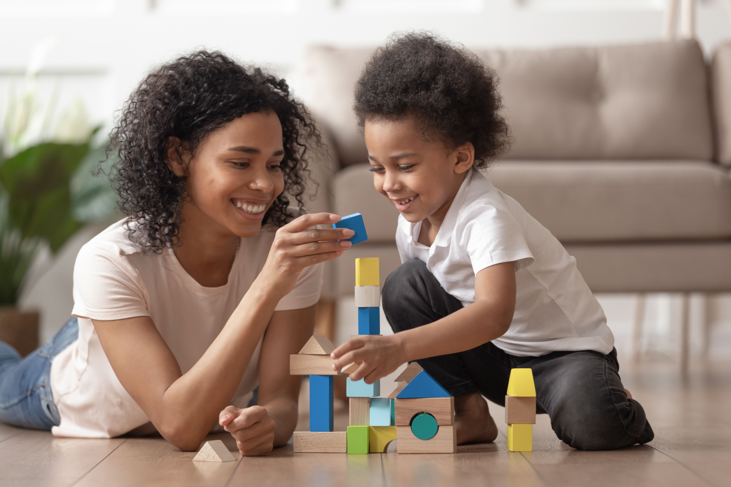 A mother and son building a tower from wooden blocks.