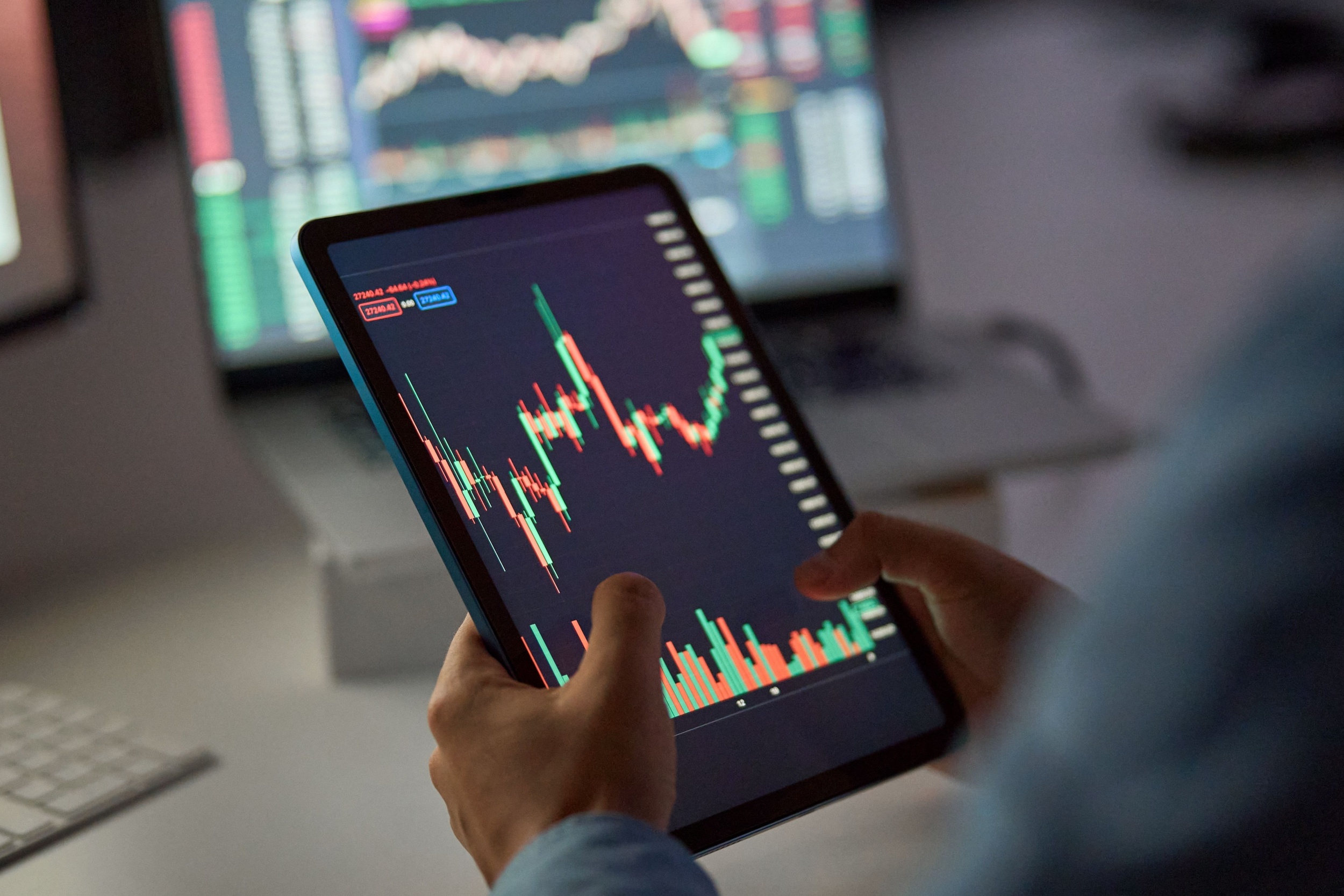 A person looking at a stock market graph on a tablet.