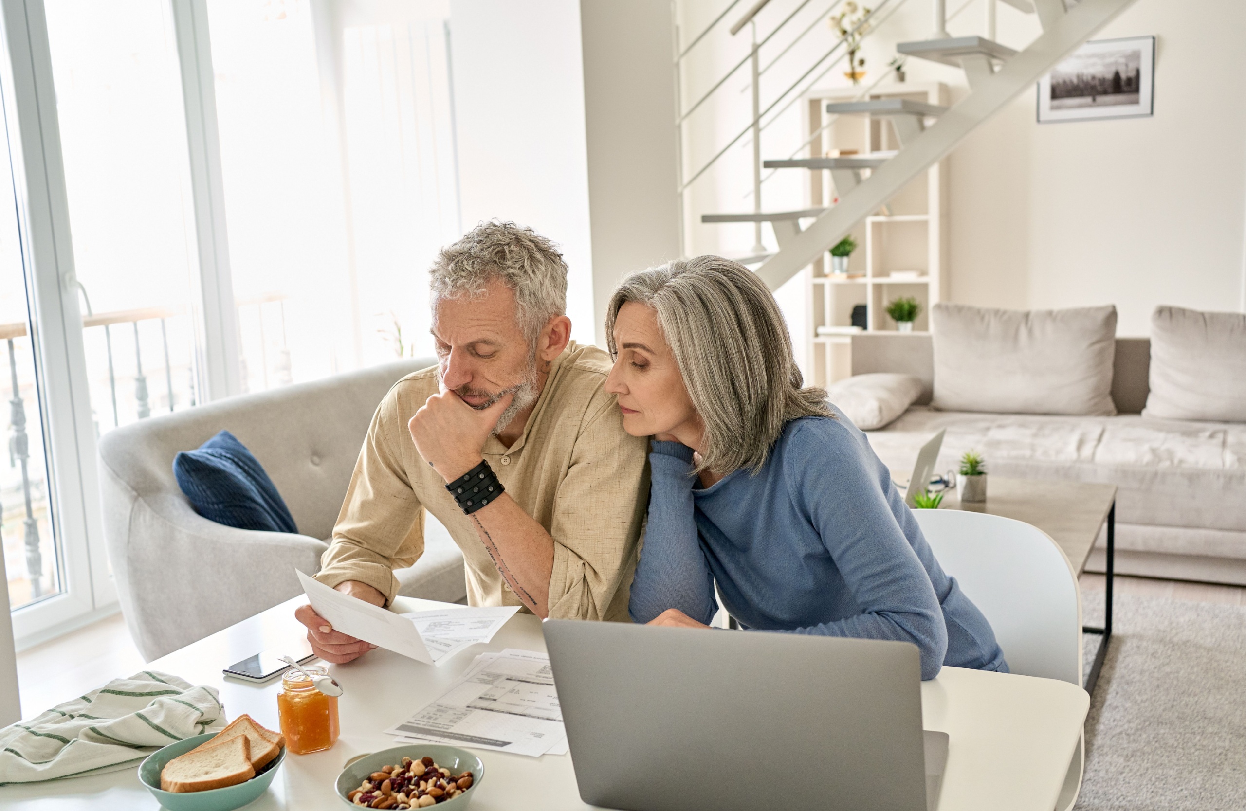 A couple looking at paperwork together in their home.