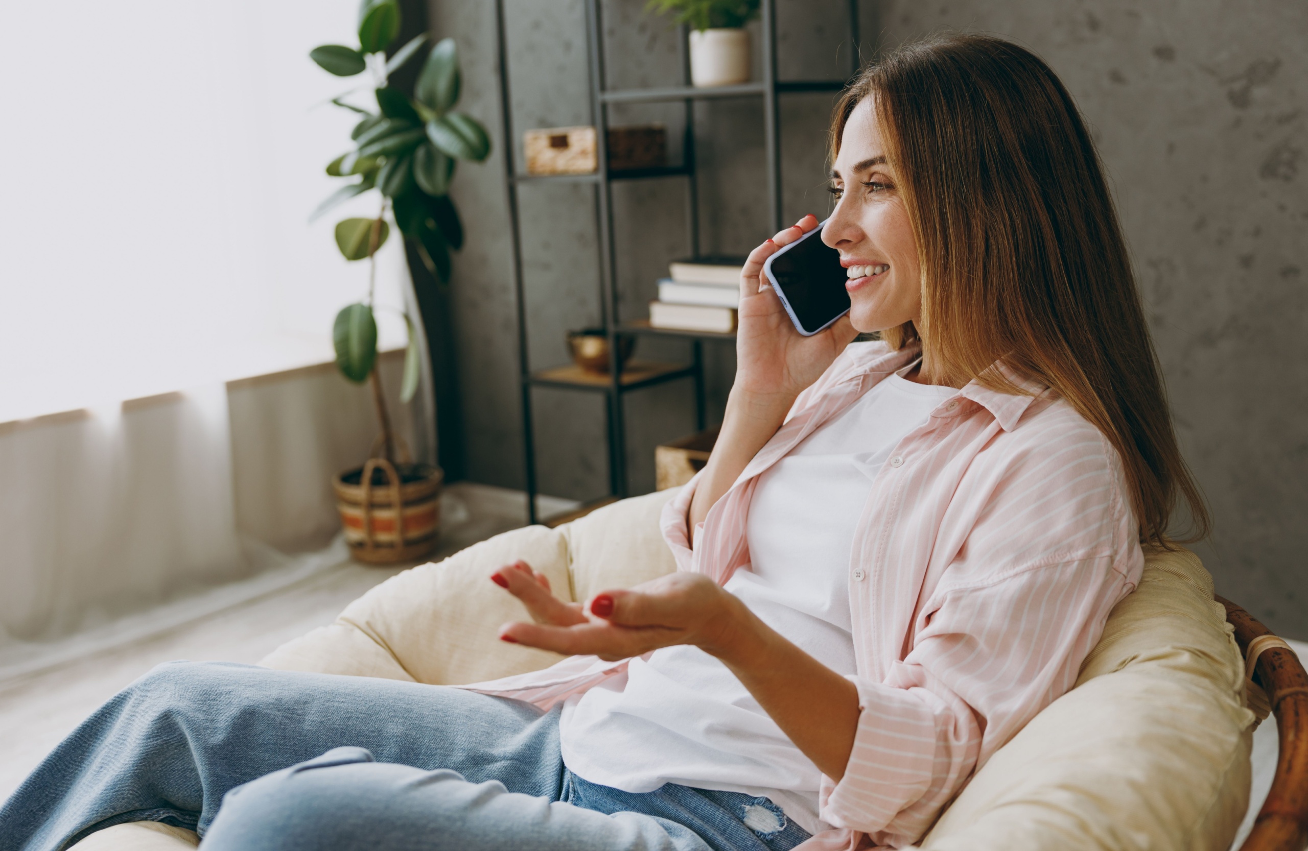 A woman talking on the phone at home.