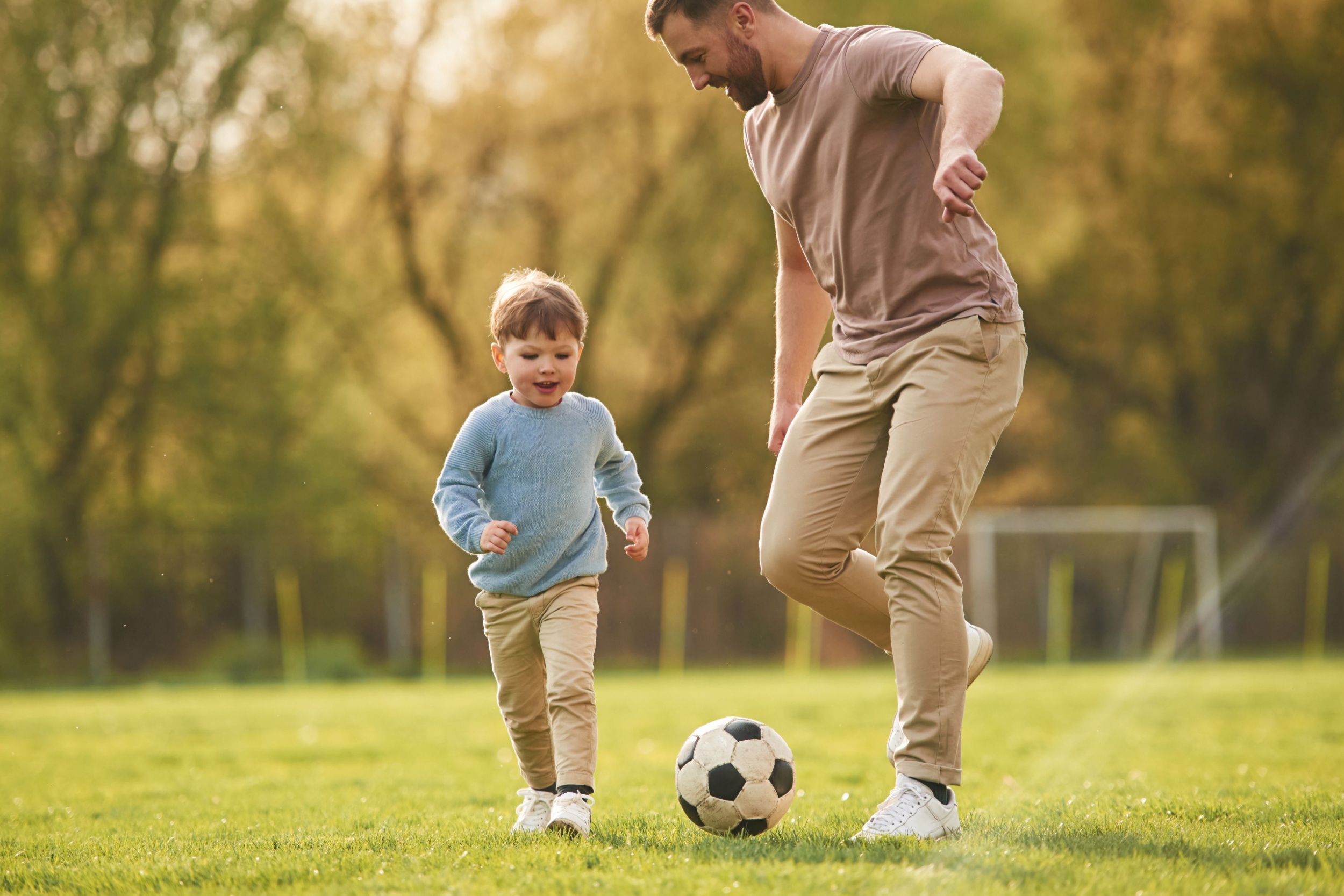 A father playing football with his young son.