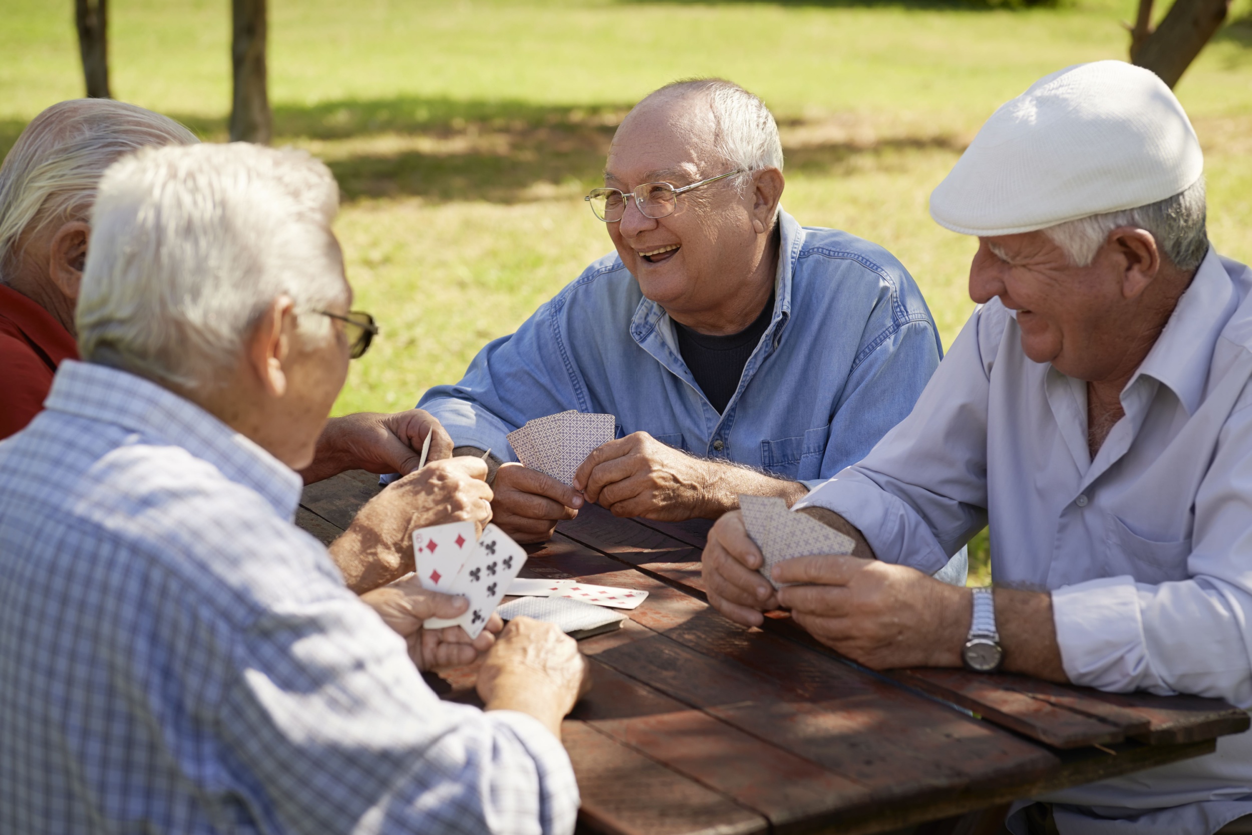 A group of friends playing cards outdoors.