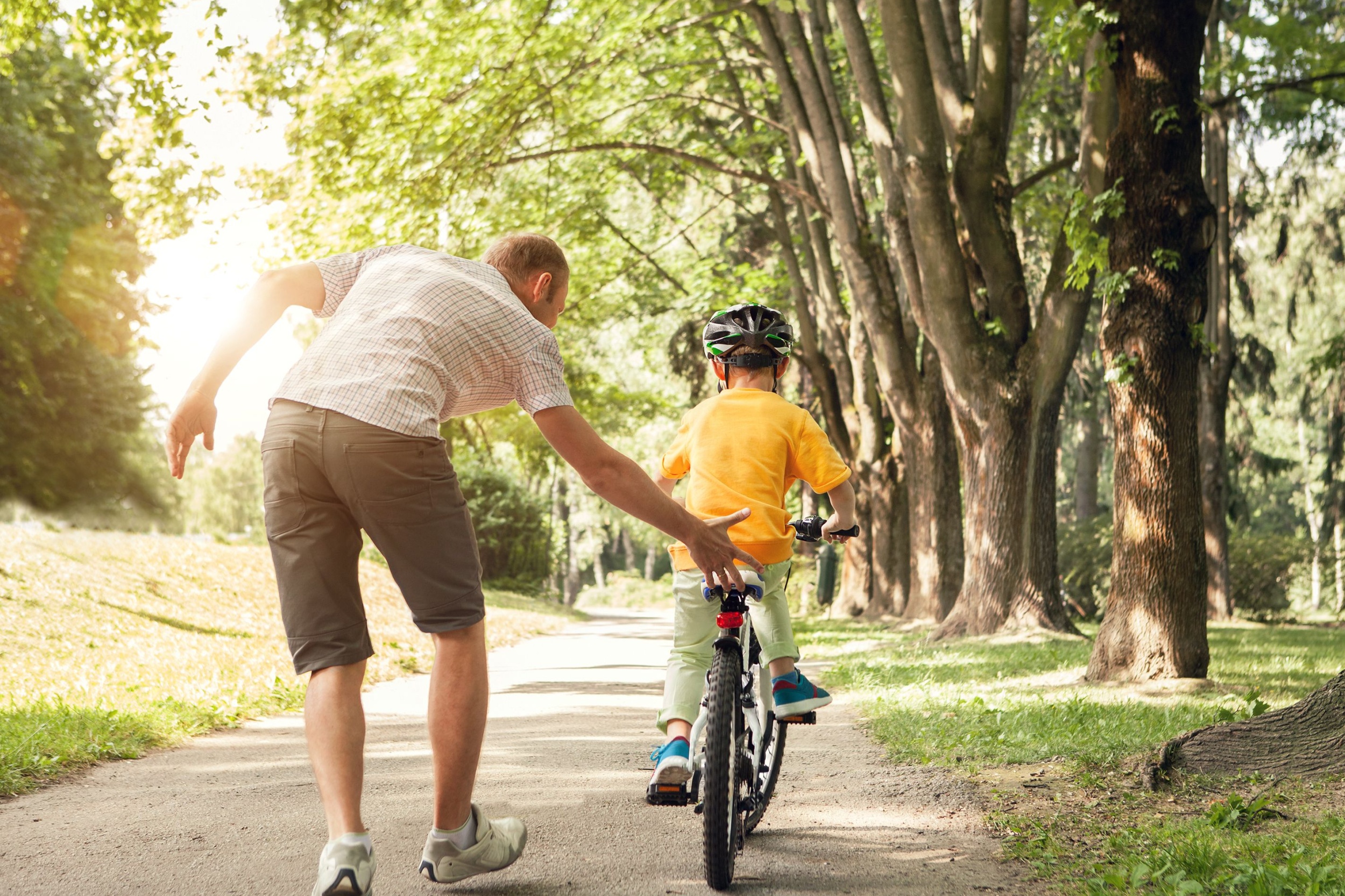 A father teaching a child to ride a bike.