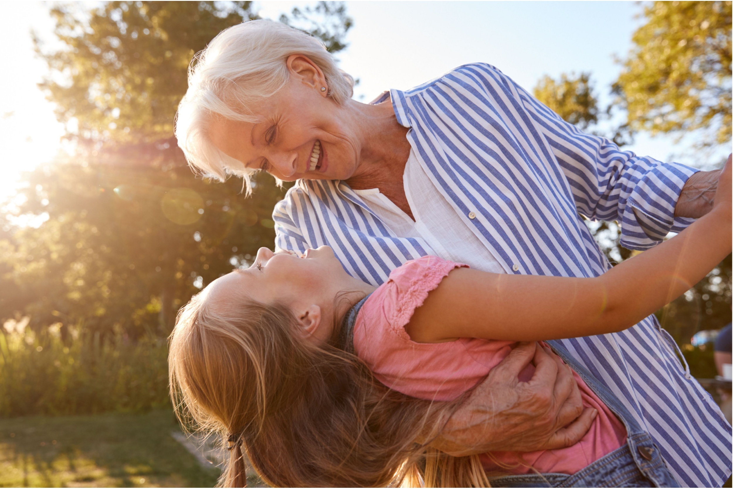 A grandmother playing with her granddaughter outside.