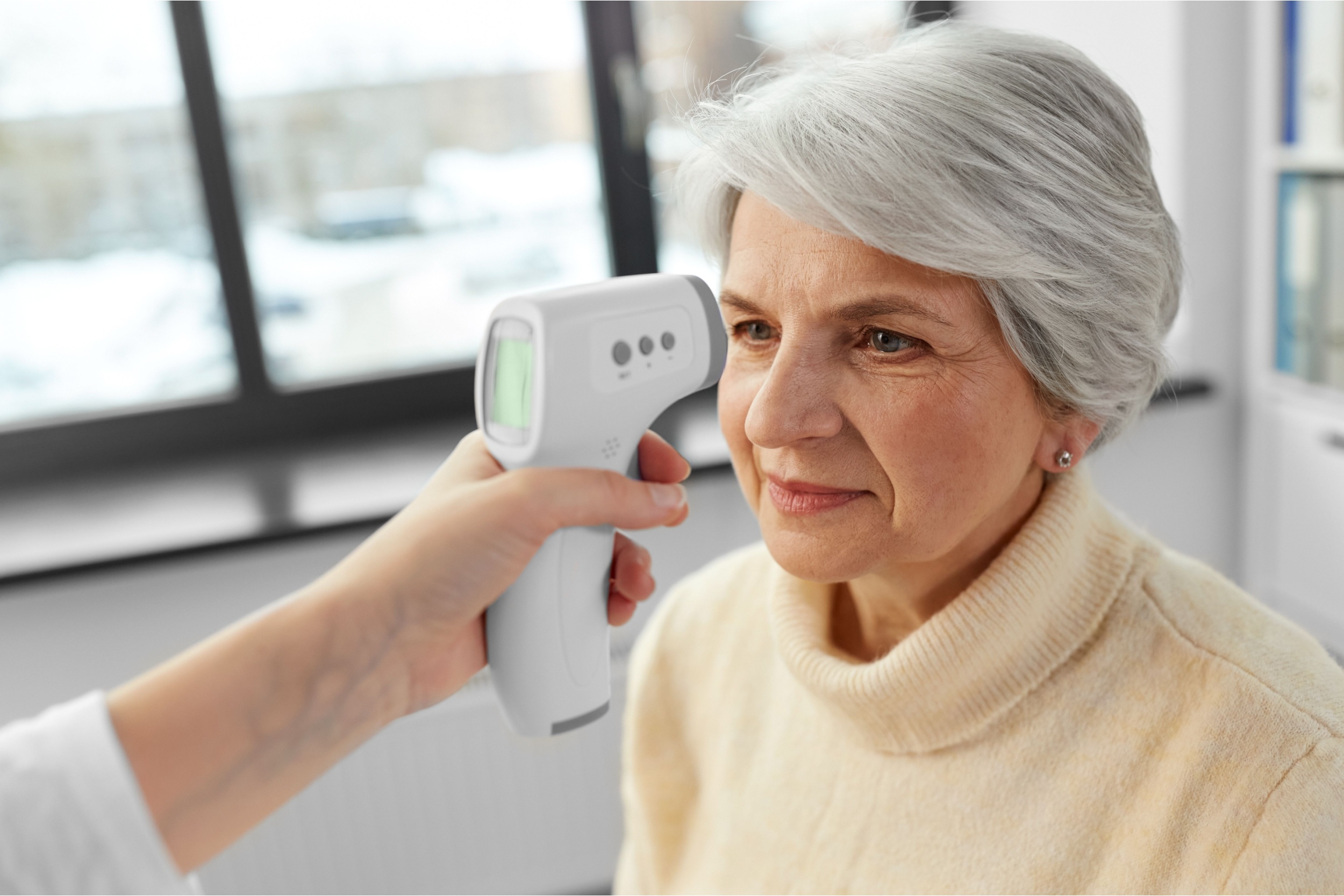 A woman having her temperature taken.