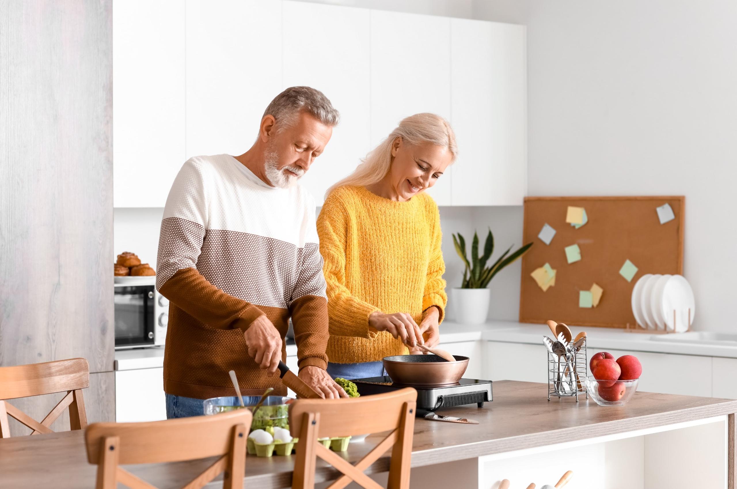 Middle-aged couple cooking a meal in the kitchen.